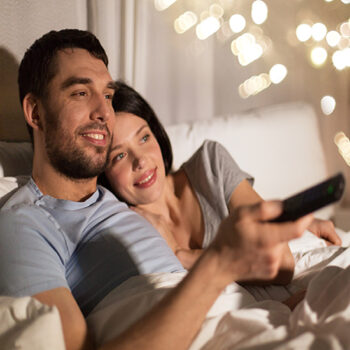 couple in bed watching tv